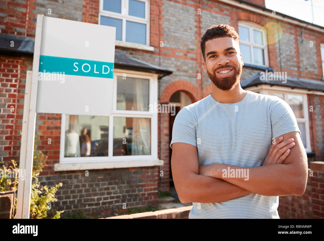 Portrait Of Excited Man Standing Outside New Home With Sold Sign Stock ...