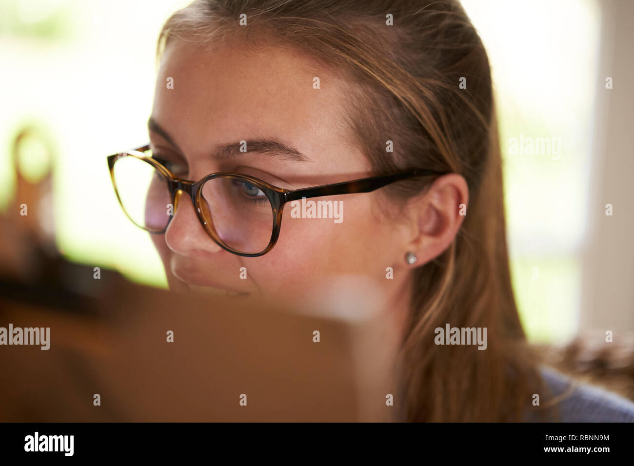 Close Up Of Female Teenage Artist Working Behind Easel Stock Photo