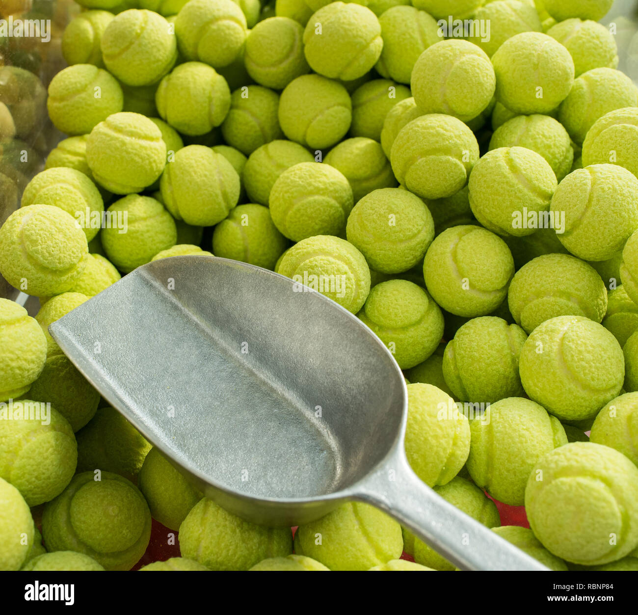 background of green sweets like tennis balls with spoon Stock Photo