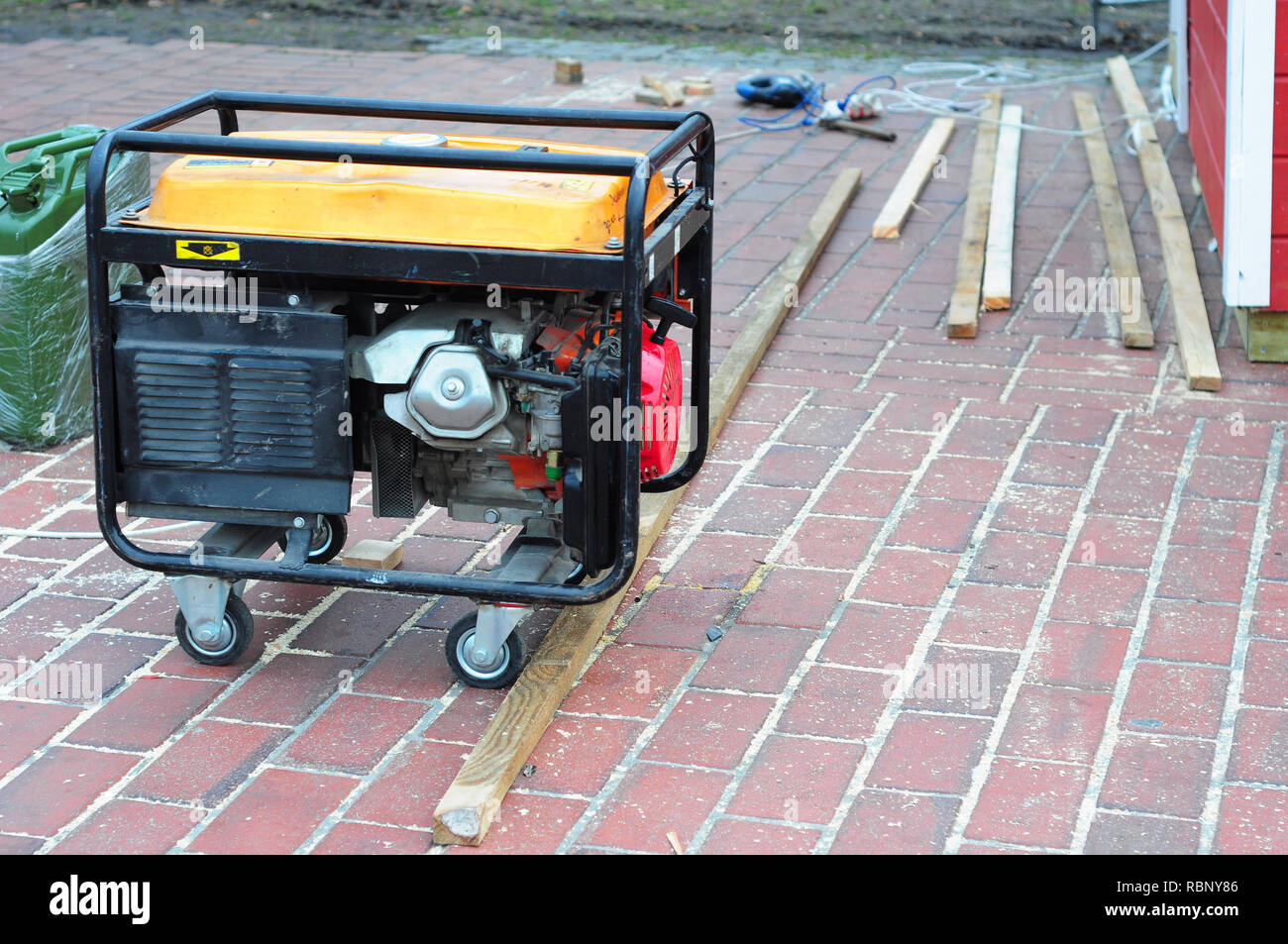 Portable Generator with wheels  on the House Construction Site. Close up on Mobile Backup Generator. Stock Photo