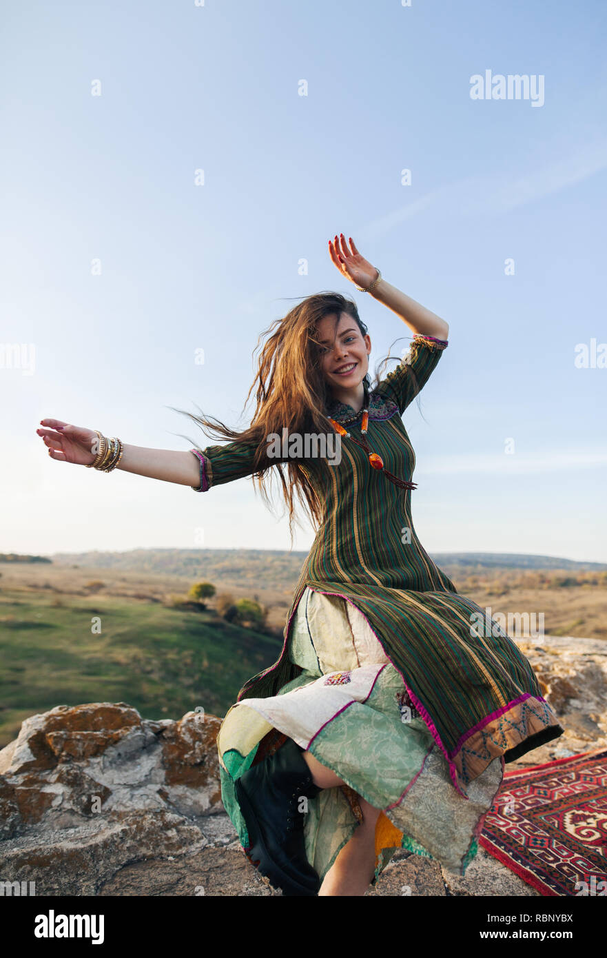 Pretty hippie girl dancing on top of mountains. Freedom and happy woman concept Stock Photo