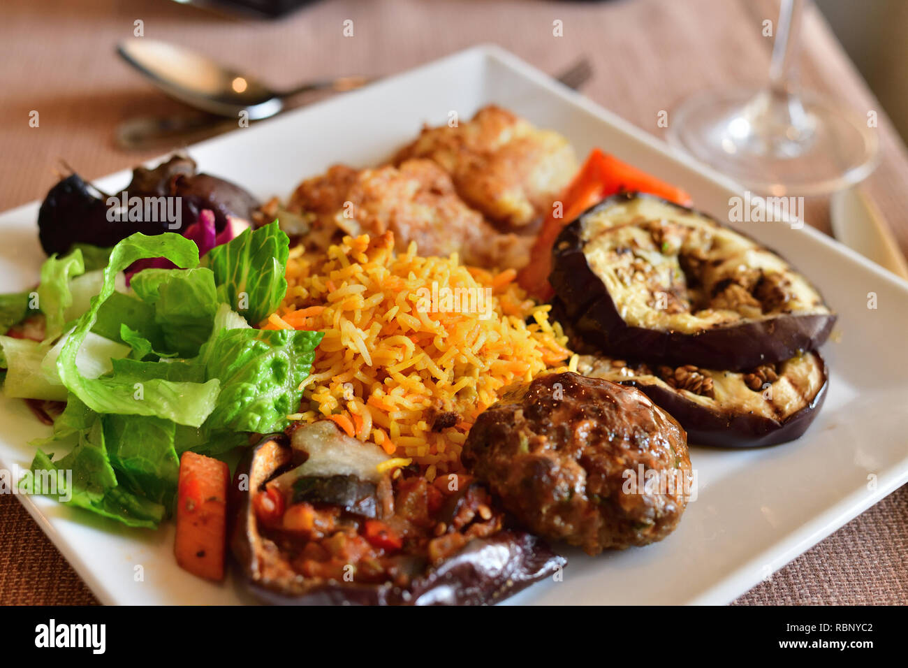 Rice and grilled vegetables and fish on a plate in cafe Stock Photo