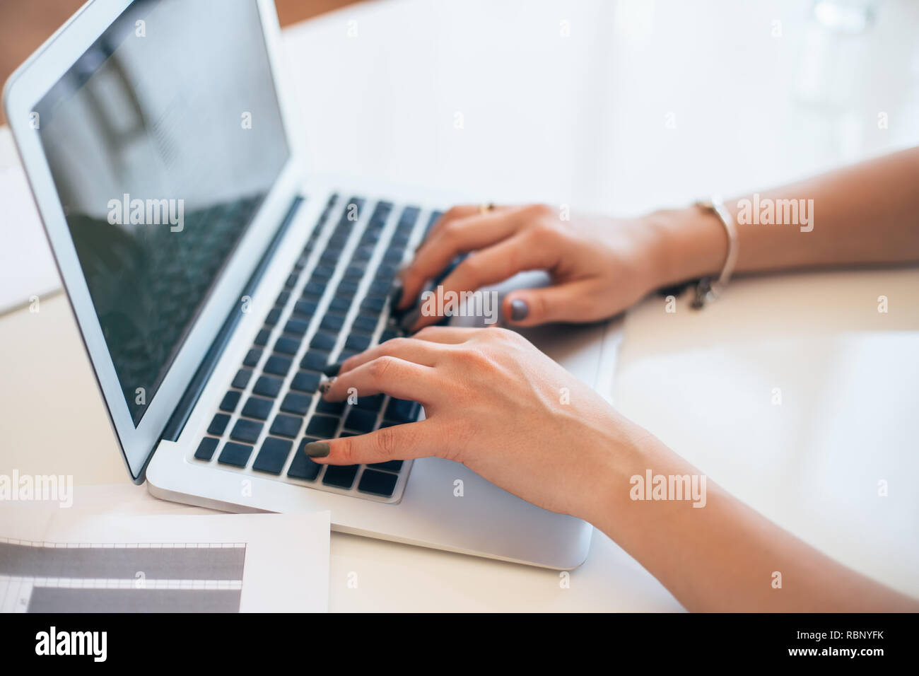 Female hands typing on a laptop keyboard. Woman working at office desk Stock Photo