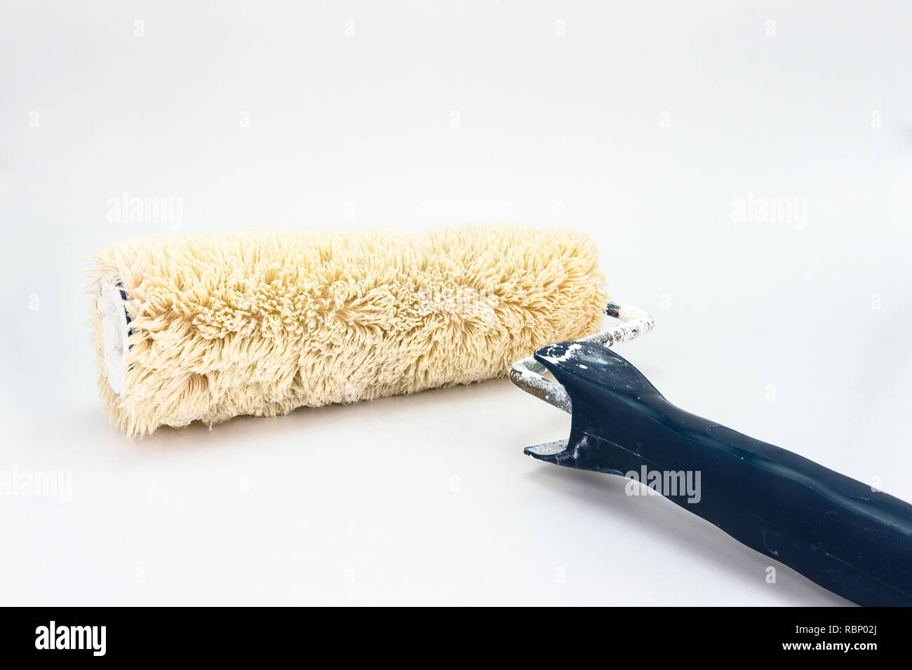 Used, dirty paint roller with a blue handle. Isolated on a white ...