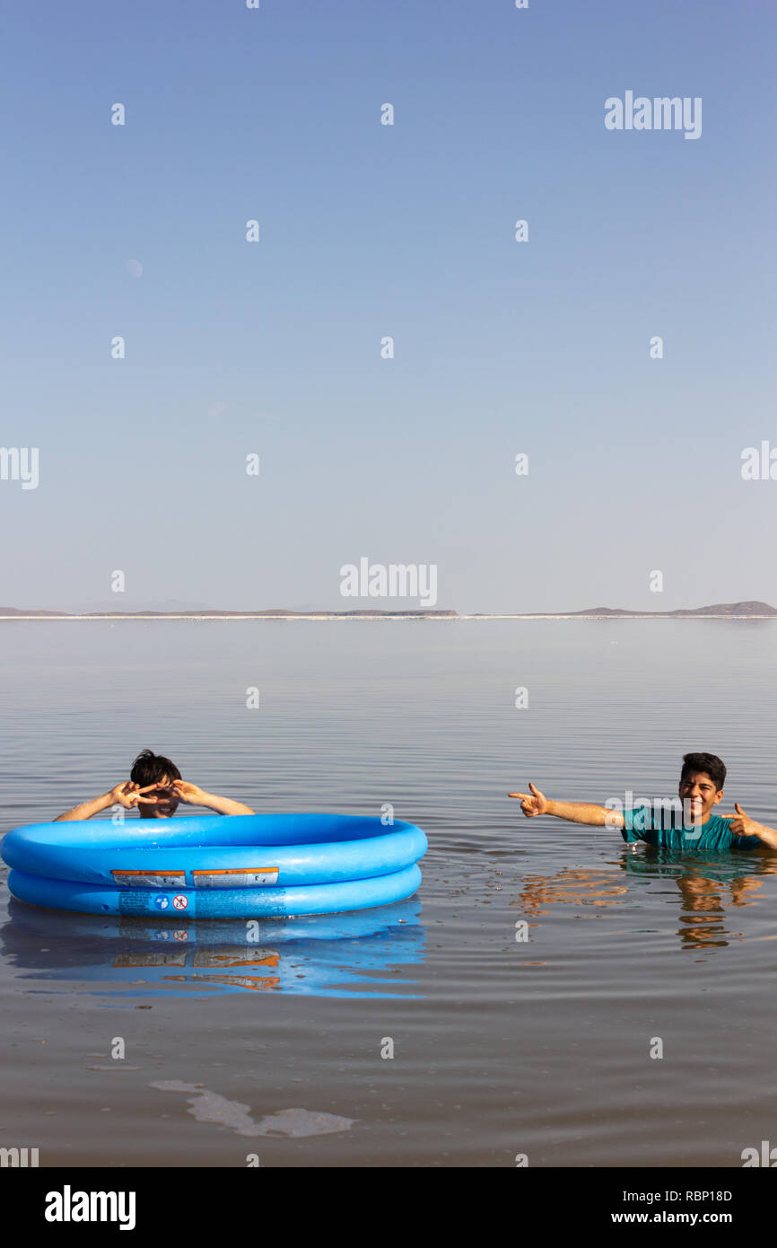 The Children Are Swimming With Their Plastic Boat In The Salt Urmia 