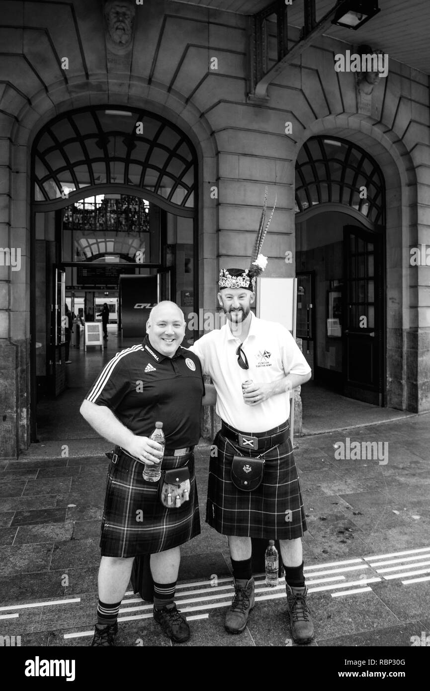 LUXEMBOURG - JUN 5, 2016: Penicuik Tartan Army - Scotland national footbal team members fan smiling posing a beer front Luxembourg central Train station - fans of the Scotland national football team Stock Photo