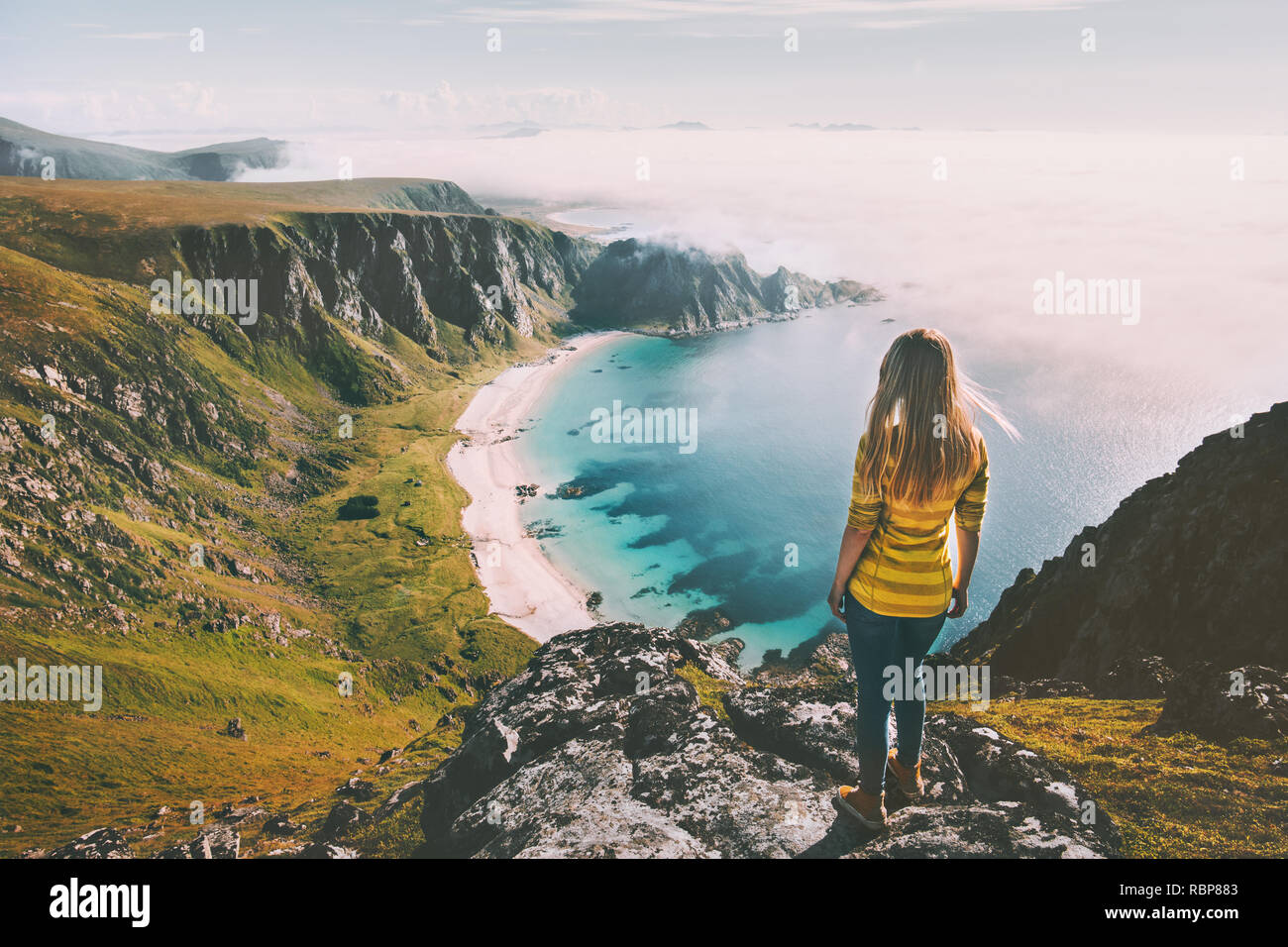 Summer travel woman tourist standing alone on mountain top over Summer travel woman tourist standing alone on mountain top over