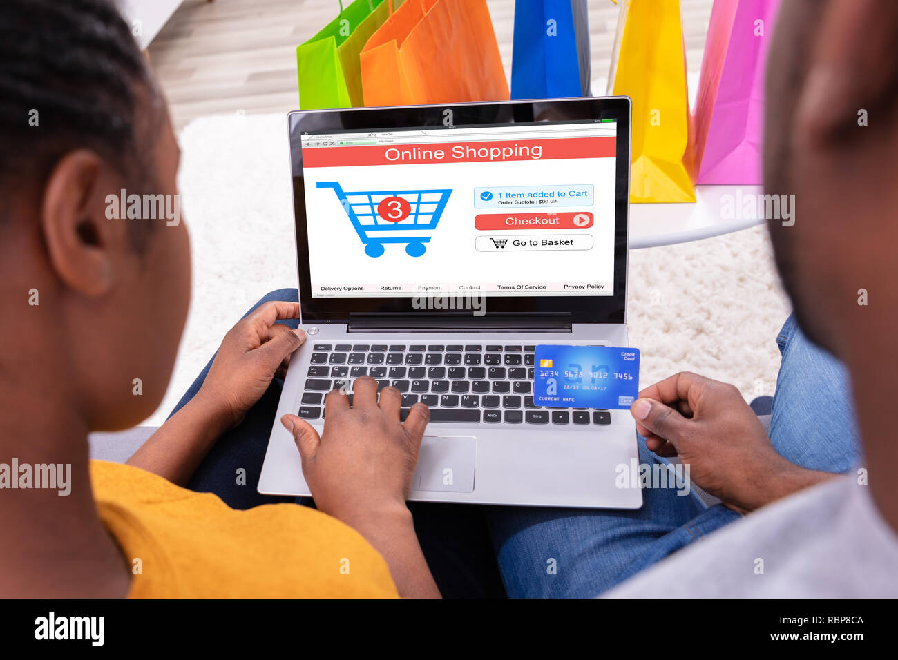 Close-up Of A Couple Using Debit Card While Shopping Online On Laptop Stock Photo