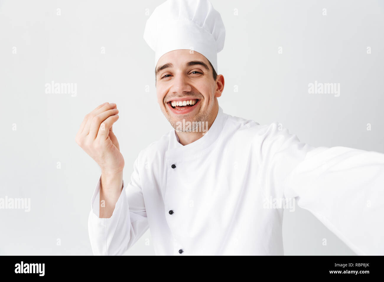 Happy chef cook wearing uniform standing isolated over white background