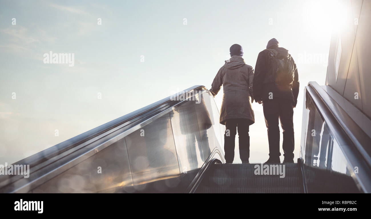 Silhouette of a couple going up an escalator Stock Photo