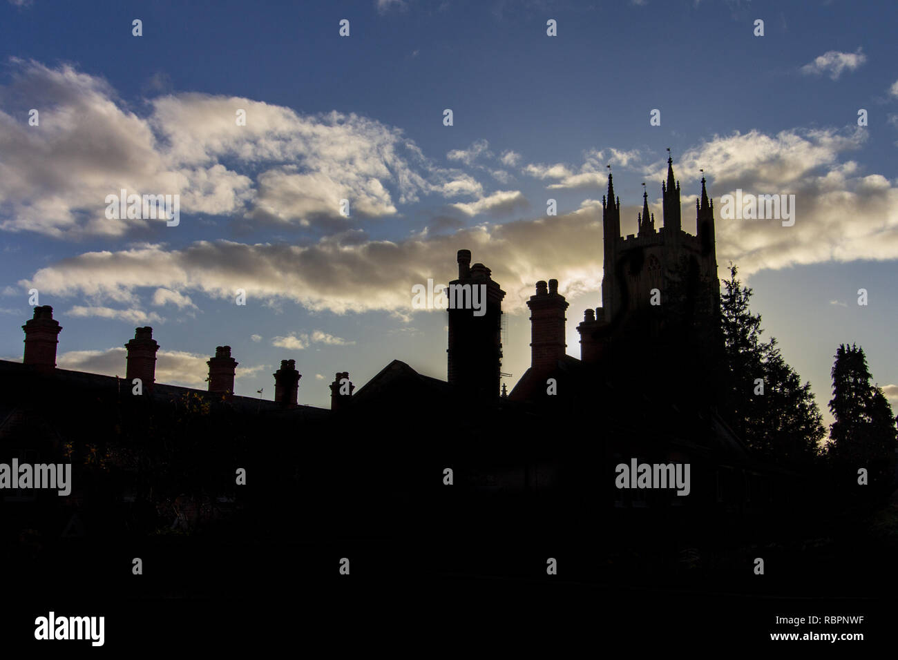 In the late afternoon light Saint John the Baptist Church is a prominent silhouette in the Glastonbury skyline Stock Photo