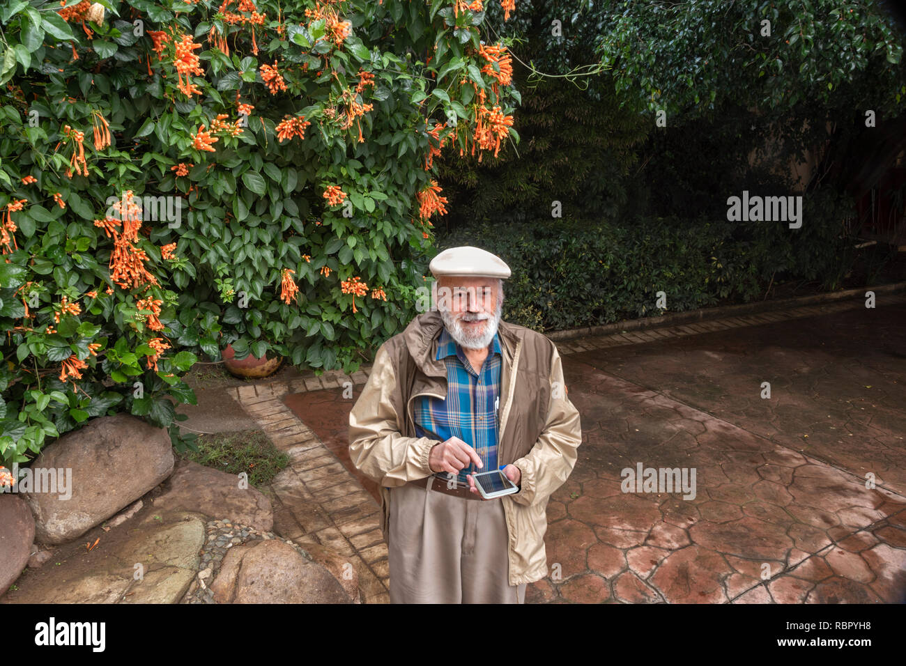 Happy senior man text messaging on a mobile smart phone in a garden Stock Photo