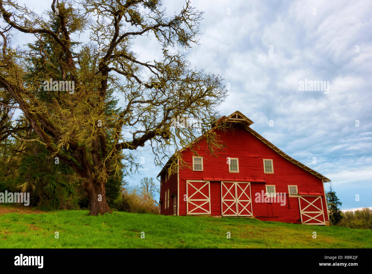 An Old Red Barn Sits On A Hillside Of A Wildlife Refuge In Rural