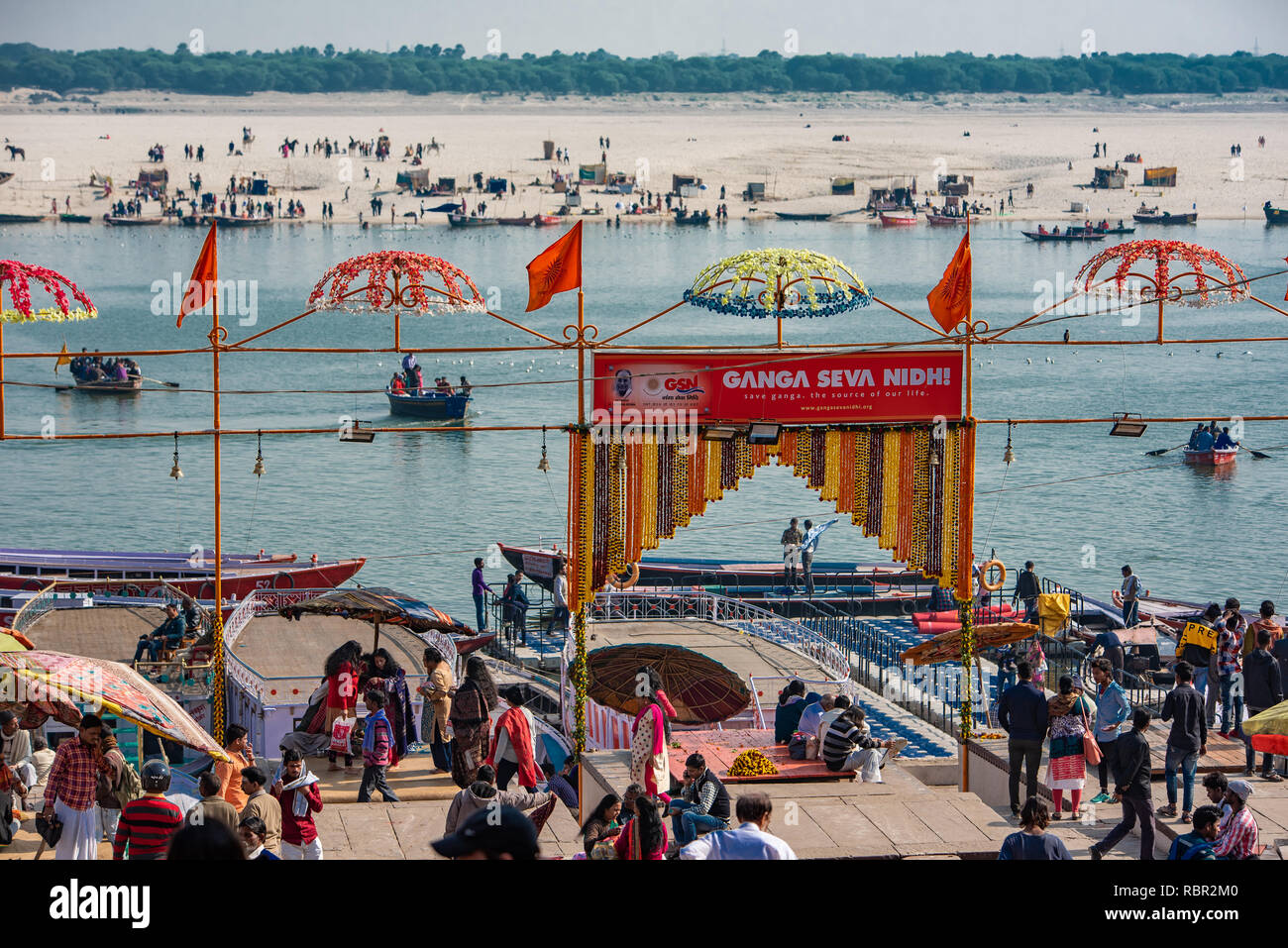 The bustling and busy Dashashwamedh Ghat at daytime with the Ganges flowing in the background in Varanasi, India Stock Photo
