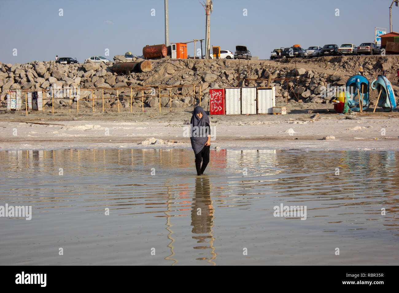 An old woman is walking in the Salt Urmia Lake, West Azerbaijan province, Iran Stock Photo