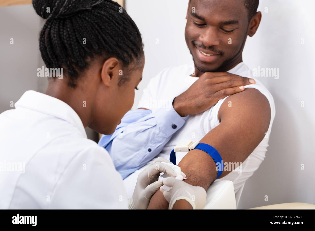 Closeup Of Female Doctor Injecting Male Patient With Syringe To