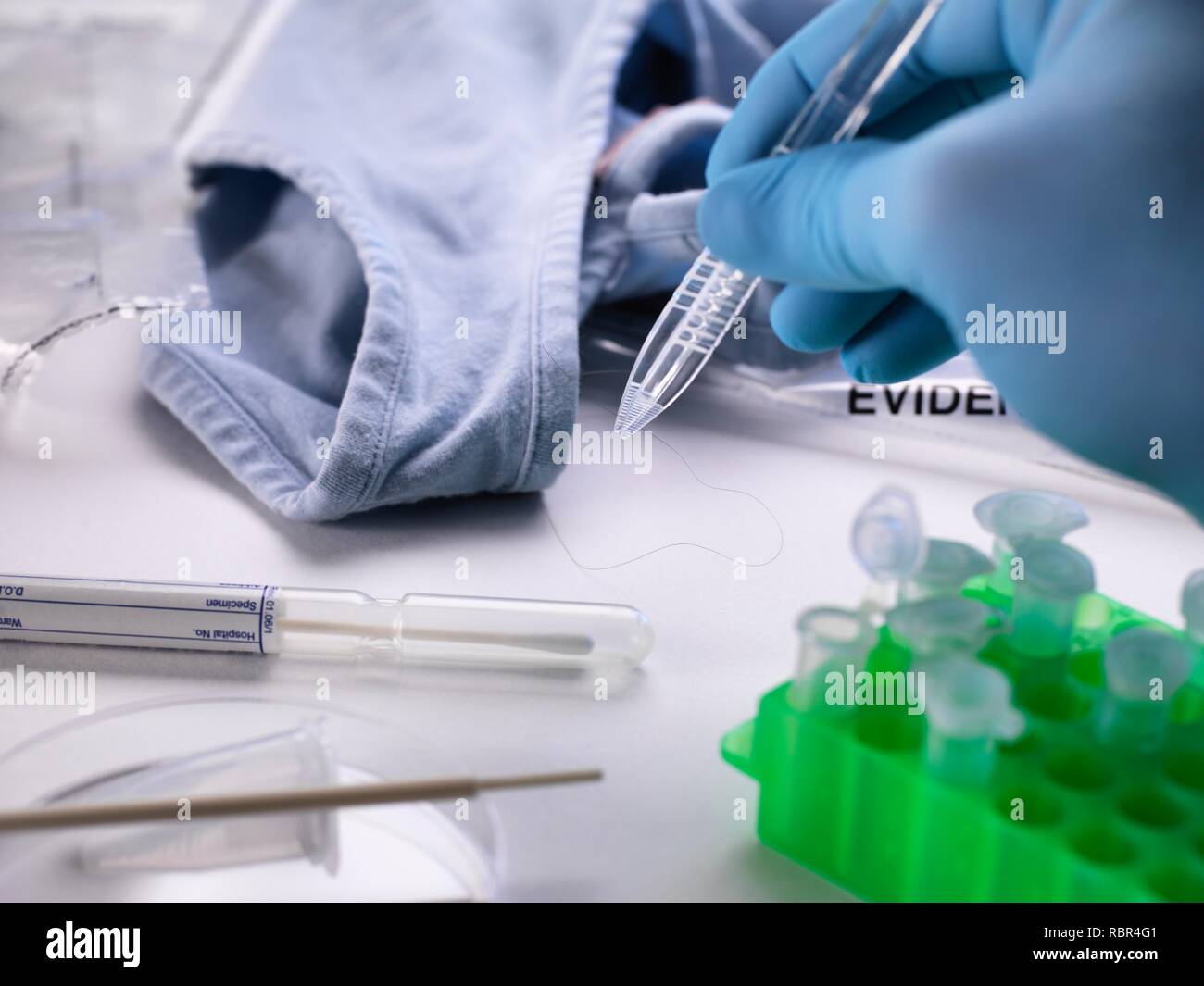 Forensic scientist taking a hair specimen for DNA (deoxyribonucleic