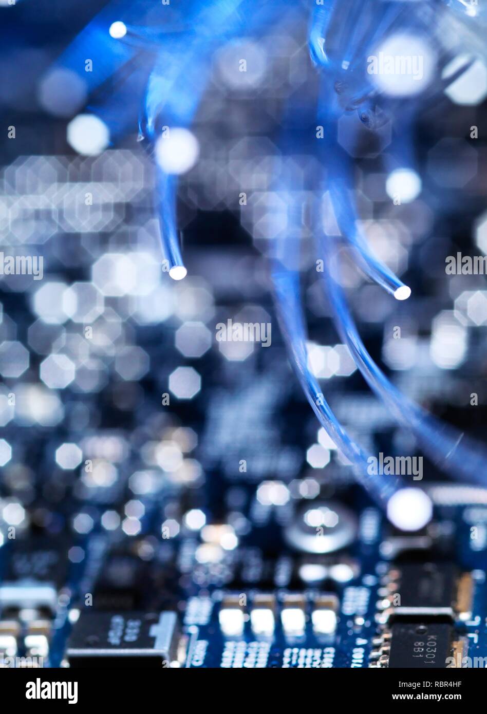 Fibre optics carrying data over electronic circuitry on a laptop computer. Stock Photo