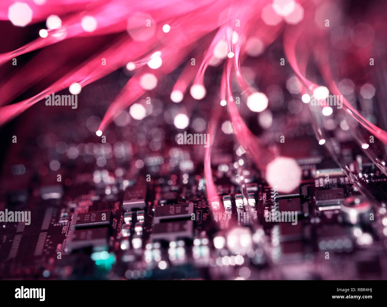 Fibre optics carrying data over electronic circuitry on a laptop computer. Stock Photo