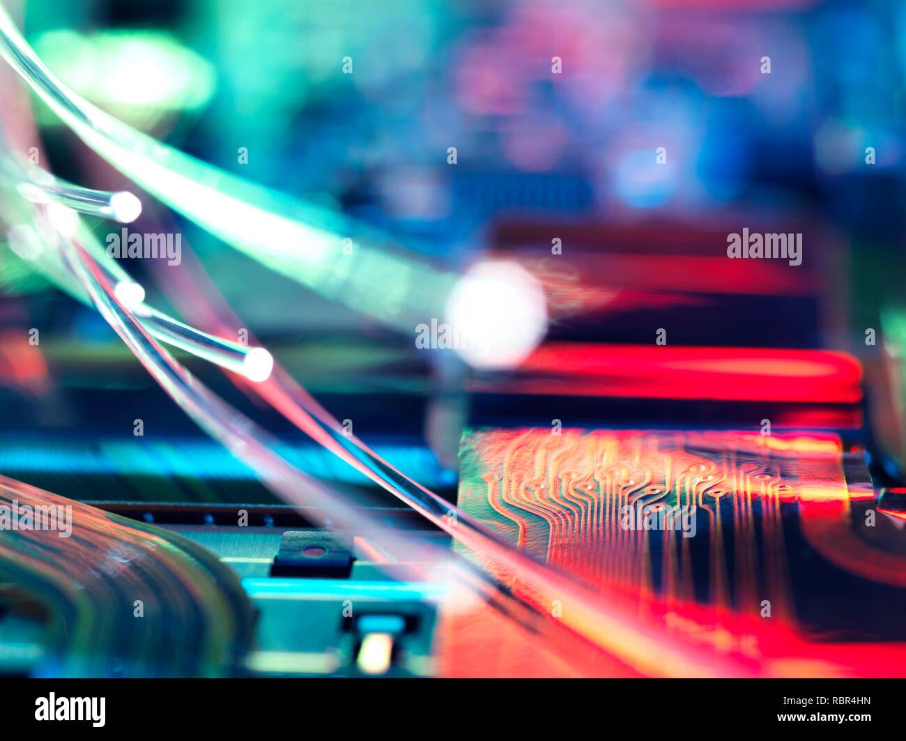 Fibre optics carrying data over electronic circuitry on a laptop computer. Stock Photo