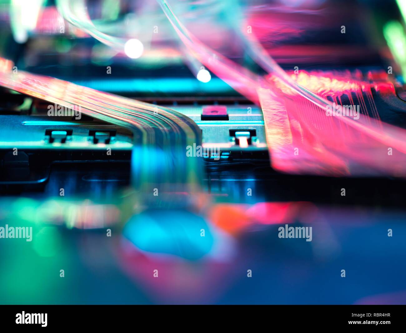 Fibre optics carrying data over electronic circuitry on a laptop computer. Stock Photo