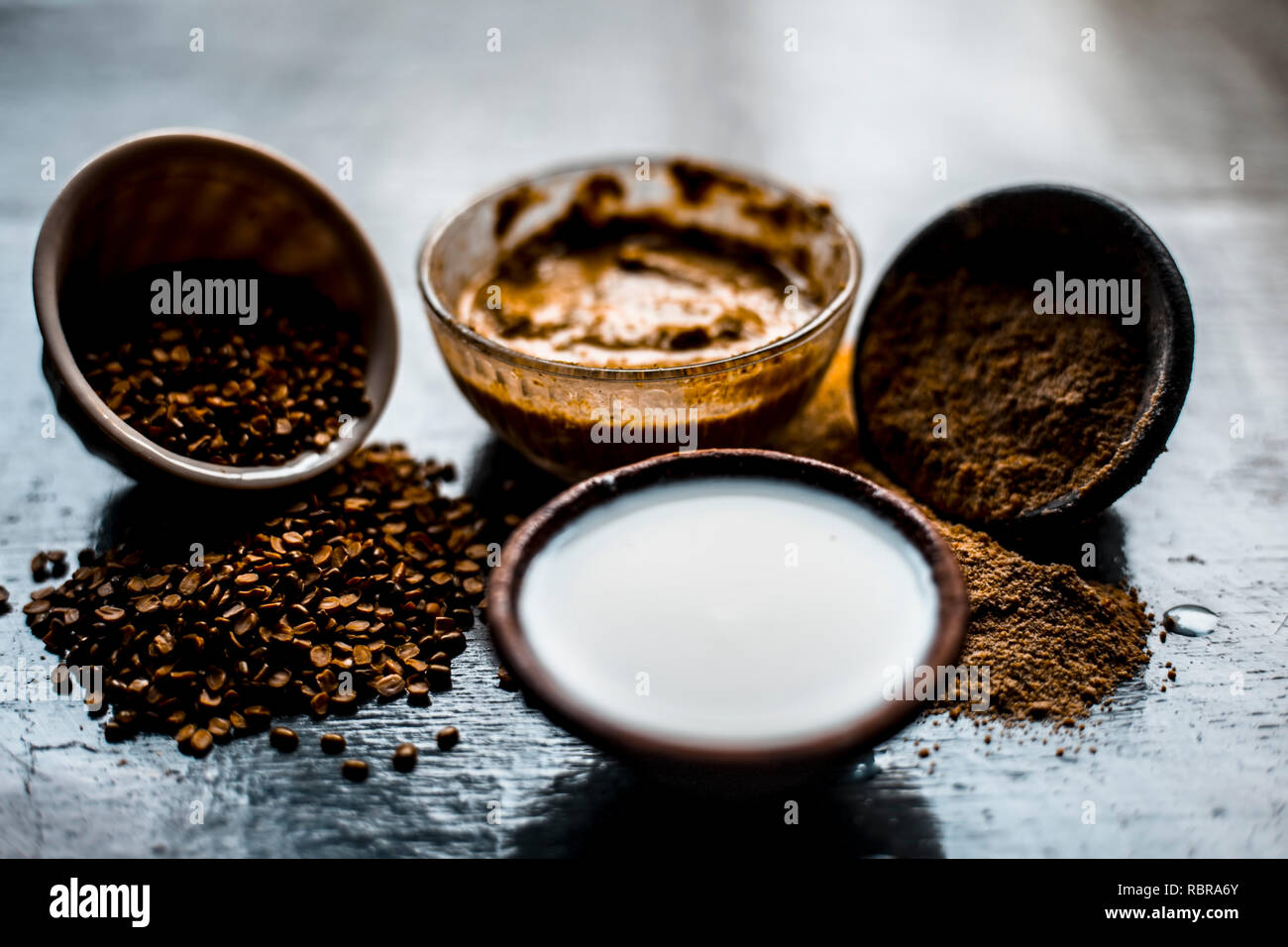 Close up of ayruevdic face pack of mung dal with sandal wood or chandan with milk and oats on wooden surface used to cure acne and pimples. Stock Photo
