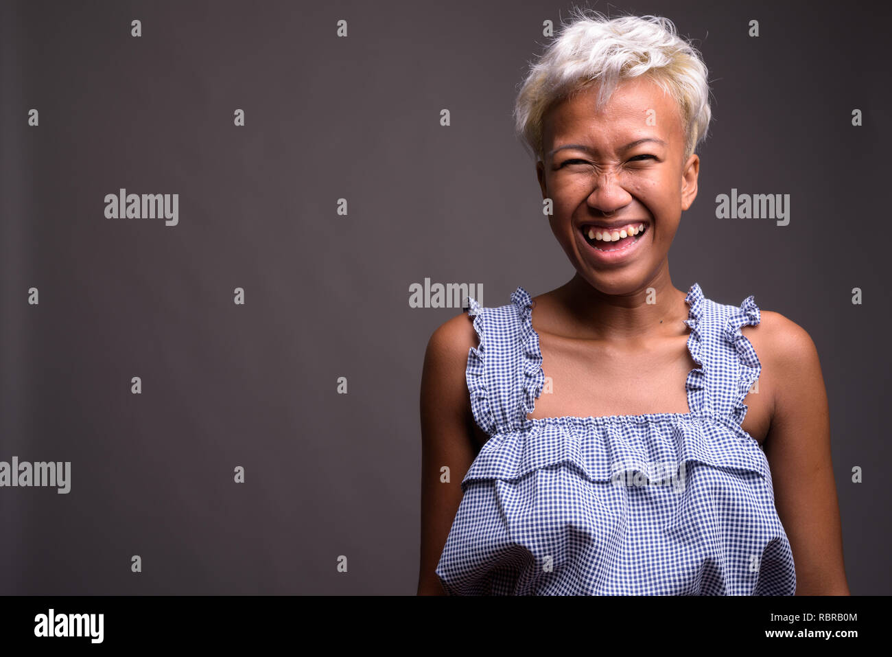 Young beautiful rebellious woman with short hair laughing Stock Photo
