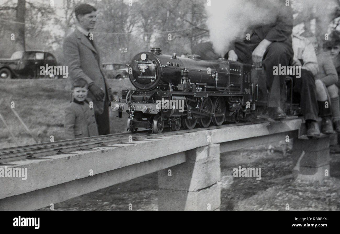 1950s, historical, father and young son looking at people riding on a ...