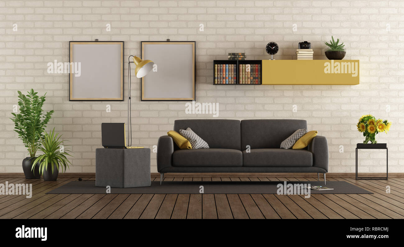 Modern living room with gray sofa,laptop on footstool and brick wall - 3d rendering Stock Photo
