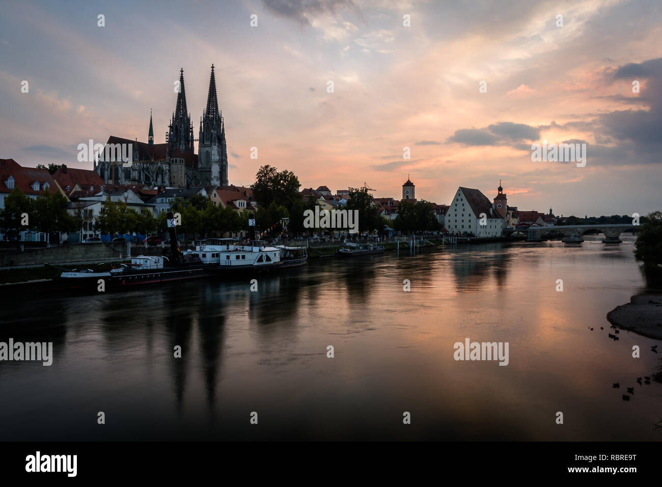 There is Saint Peter cathedral in Regensburg, Bavaria, Germany. Cityscape image over the Danube river during sunset. Stock Photo