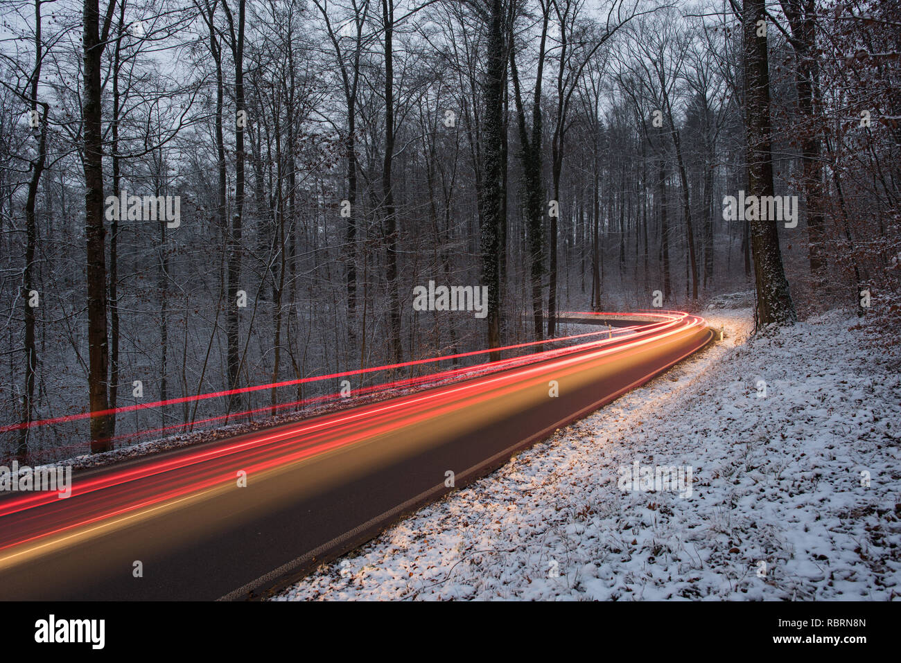 wintry road with light trails from cars Stock Photo