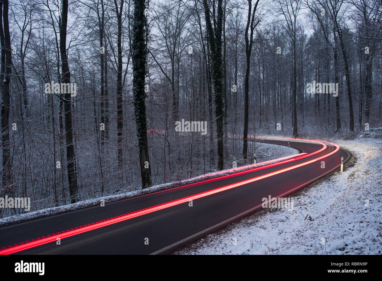 wintry road with light trails from cars Stock Photo