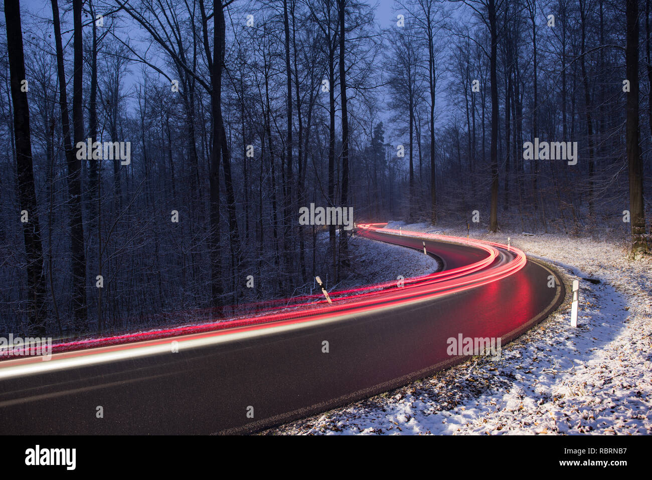 wintry road with light trails from cars Stock Photo