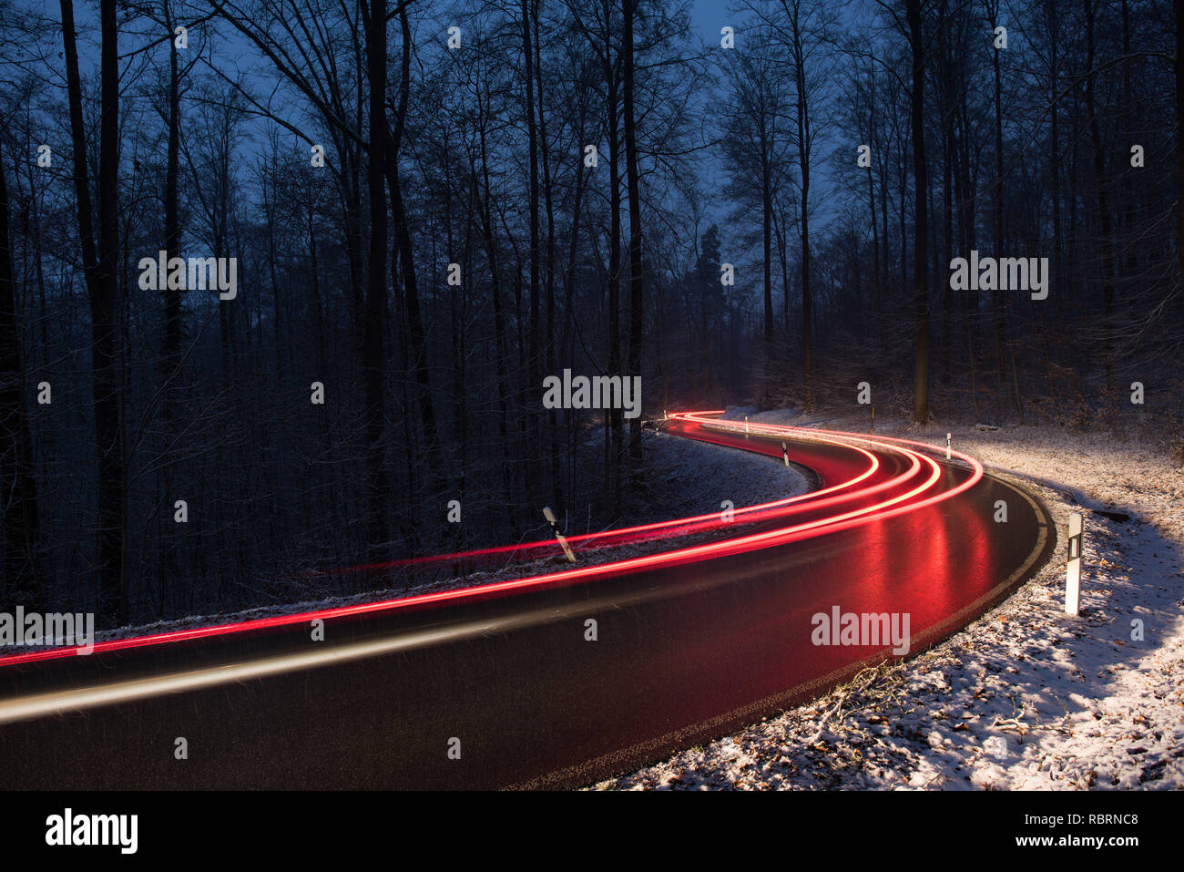 wintry road with light trails from cars Stock Photo