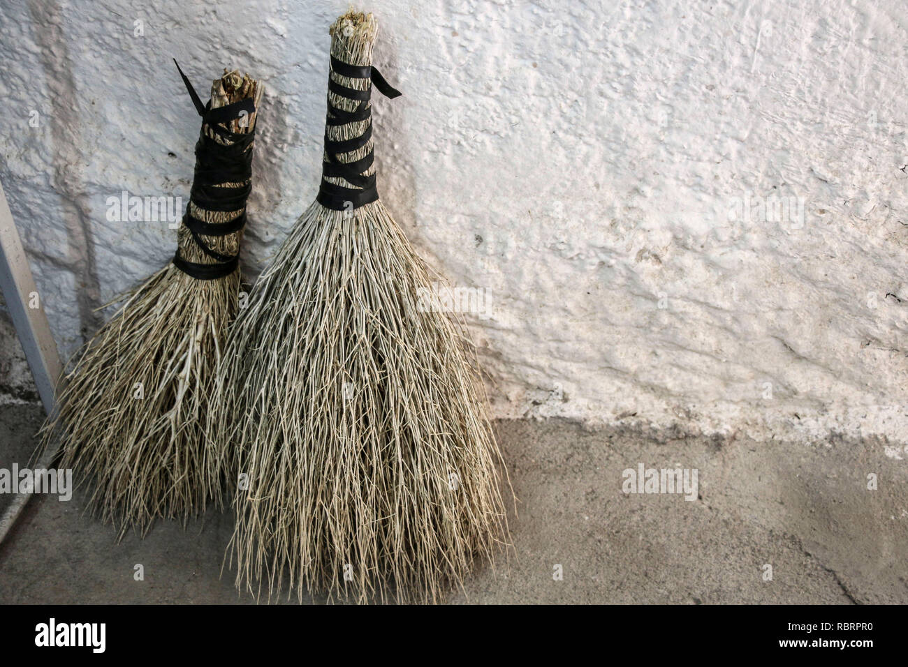 Natural handmade brooms  near white plain wall Stock Photo