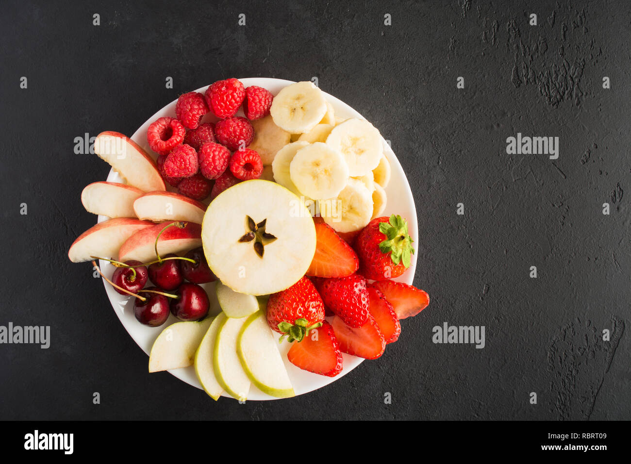Healthy vegan fruit snack in bowl. Apple, strawberries, raspberries