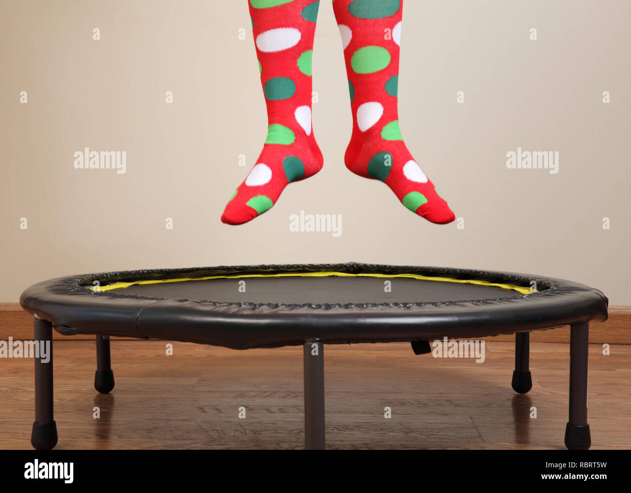 woman jumping on small trampoline showing feet with crazy socks Stock Photo
