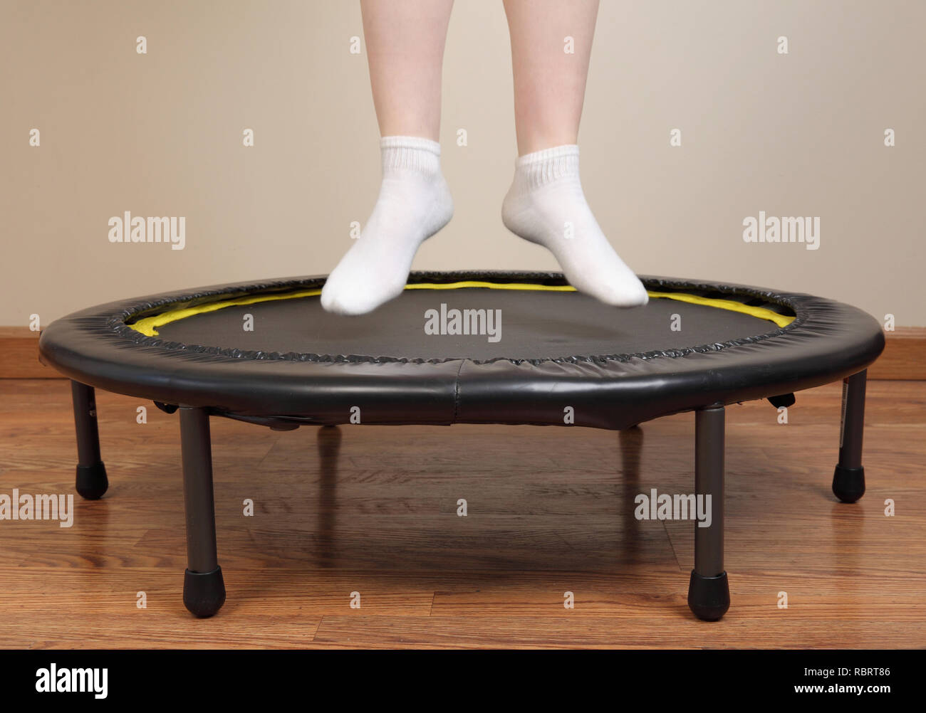 woman jumping on small trampoline showing feet and lower legs only Stock Photo