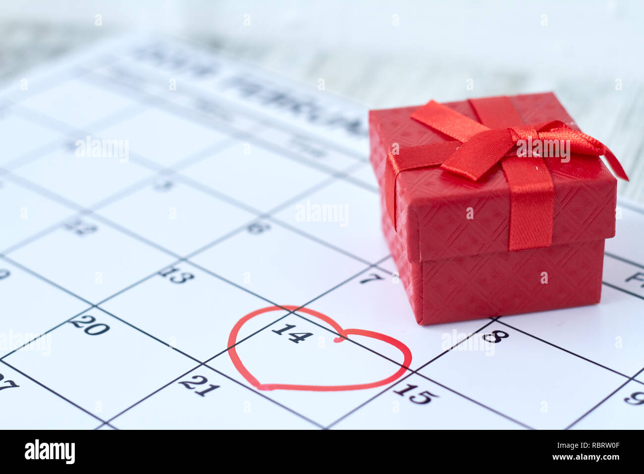 Red gift box in February for Valentine's day. Top view of the calendar. Date marked. Stock Photo
