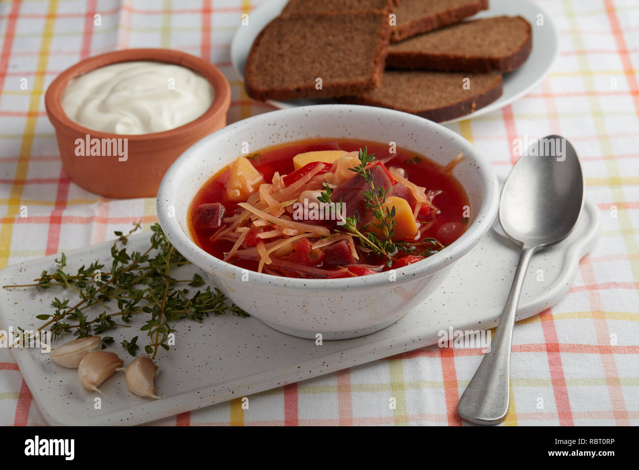 Borscht, the vegetable soup with beetroot, potato, cabbage, tomato, with garlic and thyme Stock Photo