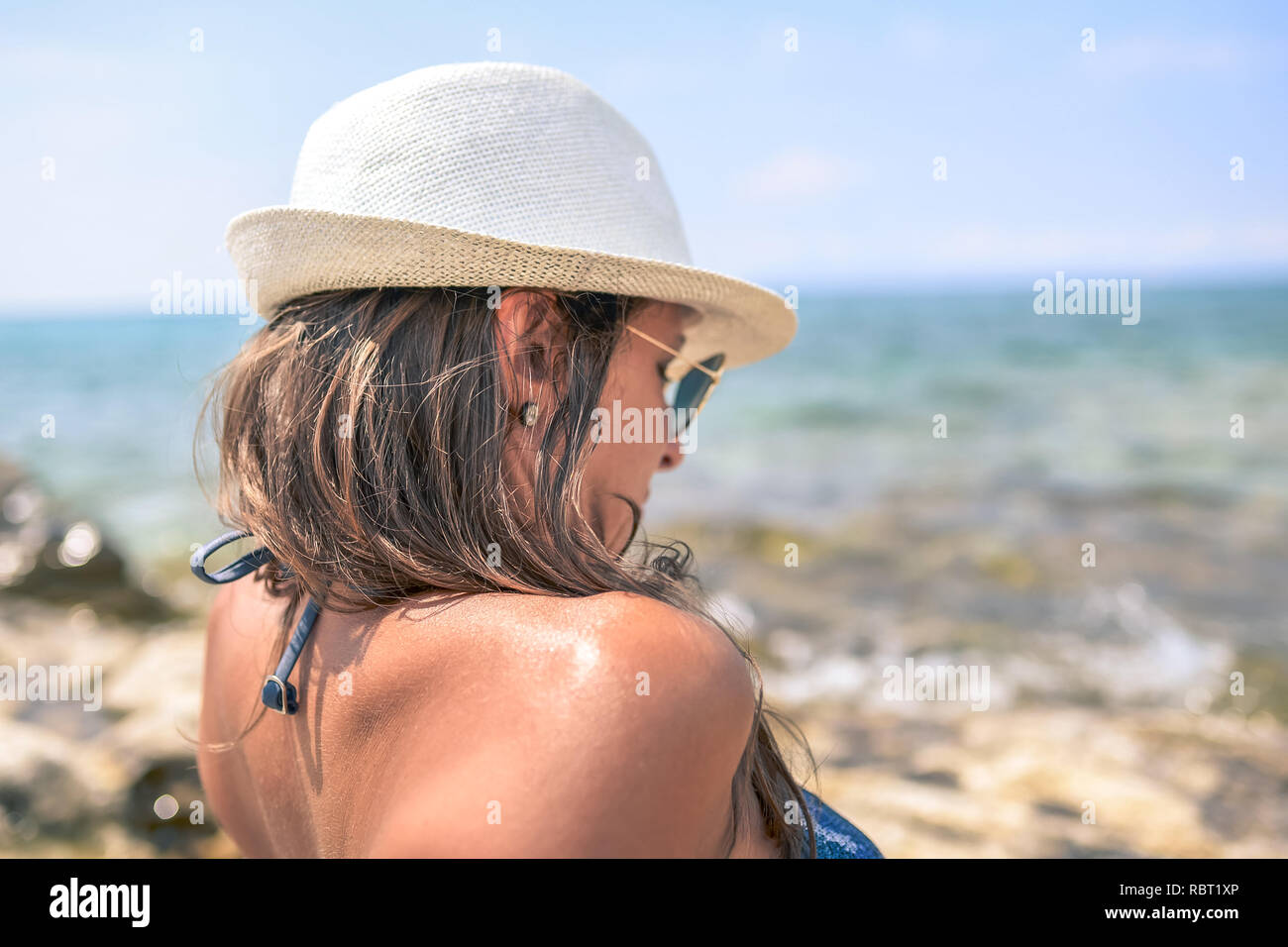 A girl with a hat on the beach Stock Photo