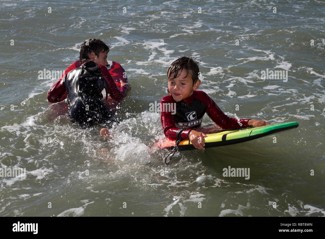 Young boys with boogy boards in the sea Stock Photo