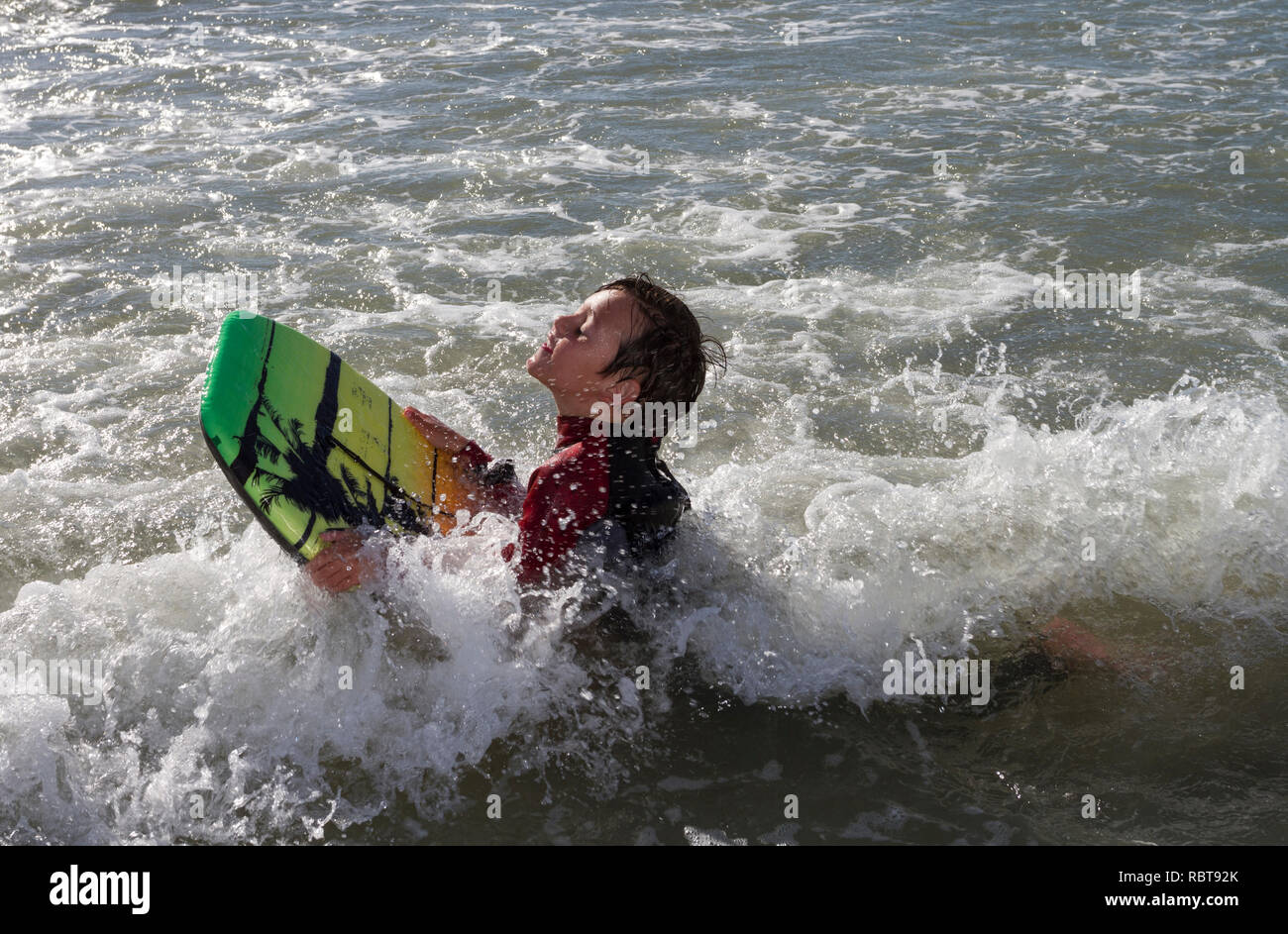 Young boy with boogy board in the sea water Stock Photo
