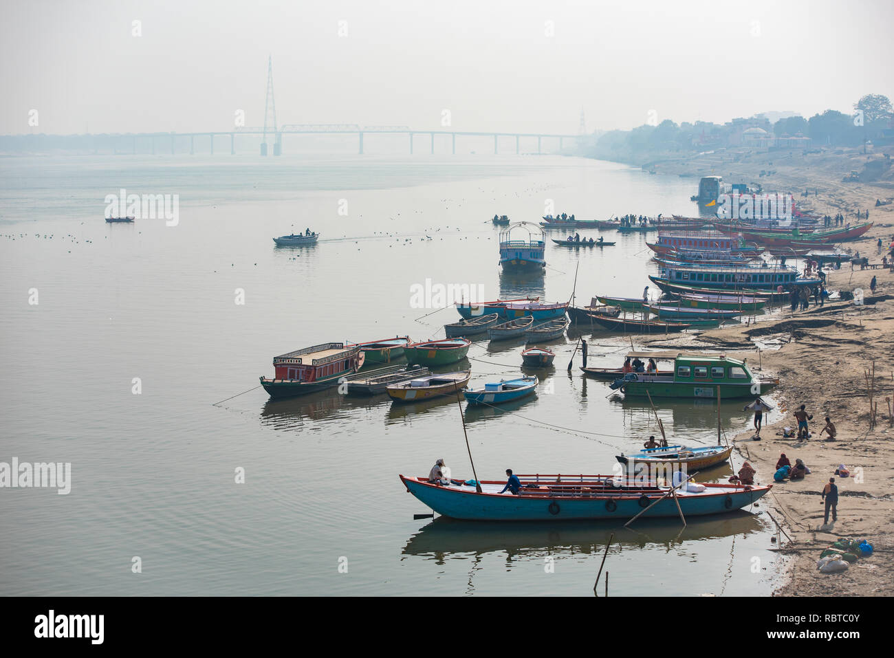 A landscape shot across the Ganges in Varanasi looking south from Assi Ghat with Ramnagar Bridge in the background and boats in the foreground. Stock Photo