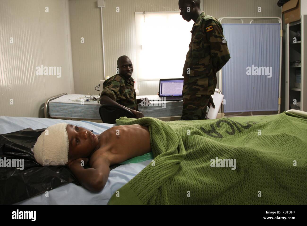 A young boy lies in the AMISOM Level II hospital on July 8 after having been wounded during fighting in Kismayo, Somalia. AU UN IST PHOTO - ILYAS A. ABUKAR (9239999156). Stock Photo