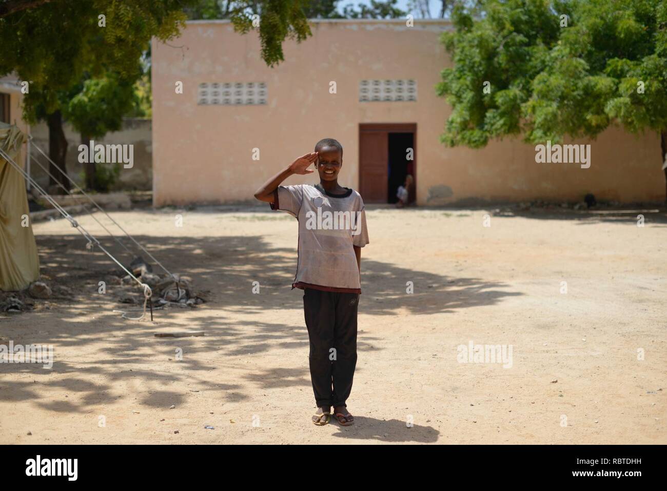 A young boy salutes at General Kahiye Police Academy in Mogadishu, Somalia, on June 16. The African Union is currently training one hundred Somali Police officers in a program aimed at equipping the (14256134930). Stock Photo