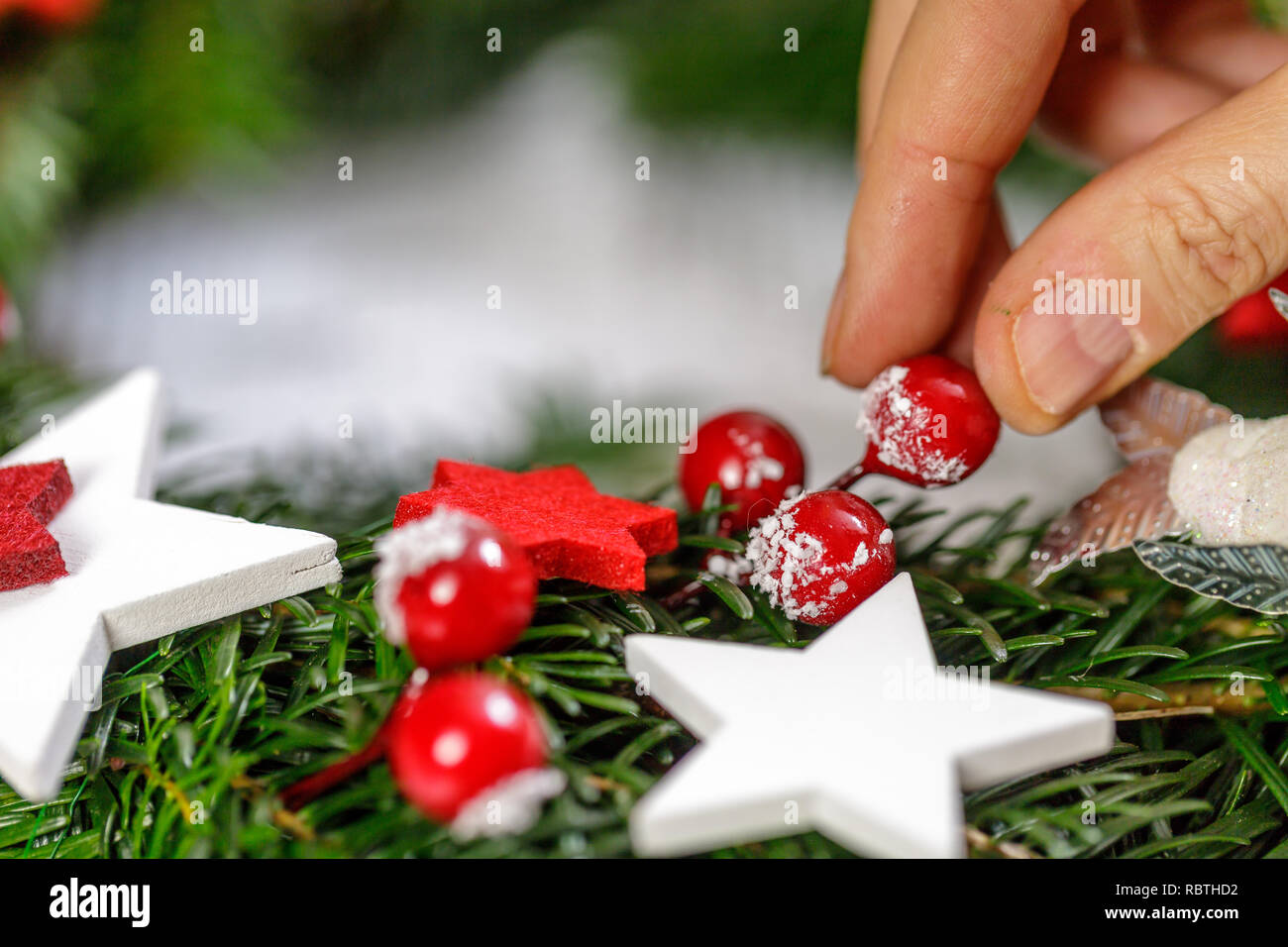 Hands of a woman decorate Christmas Advent wreath from fir twigs. Stock Photo