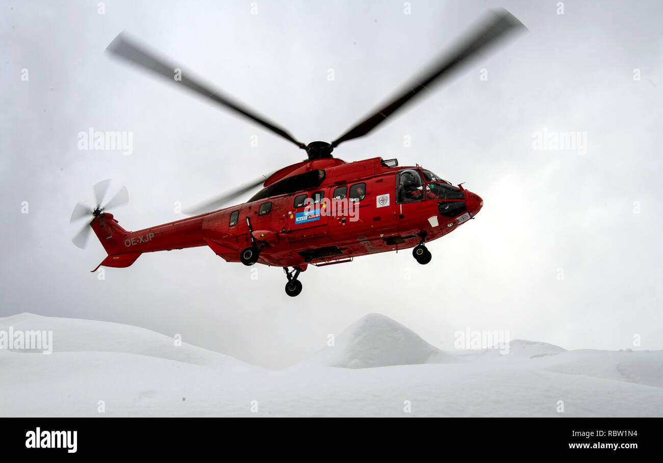 12 January 2019, Bavaria, Schönau Am Königssee: A Super Puma helicopter takes off. The helicopter is supposed to whirl the snow from trees on roads and thus reduce the risk of branch breakage. The heavy snowfalls of the past few days continue to keep the emergency forces in suspense in southern Bavaria and new snow is already approaching. According to the authorities, more than 1000 helpers have been deployed in the southern districts of Upper Bavaria. Photo: Lino Mirgeler/dpa Stock Photo