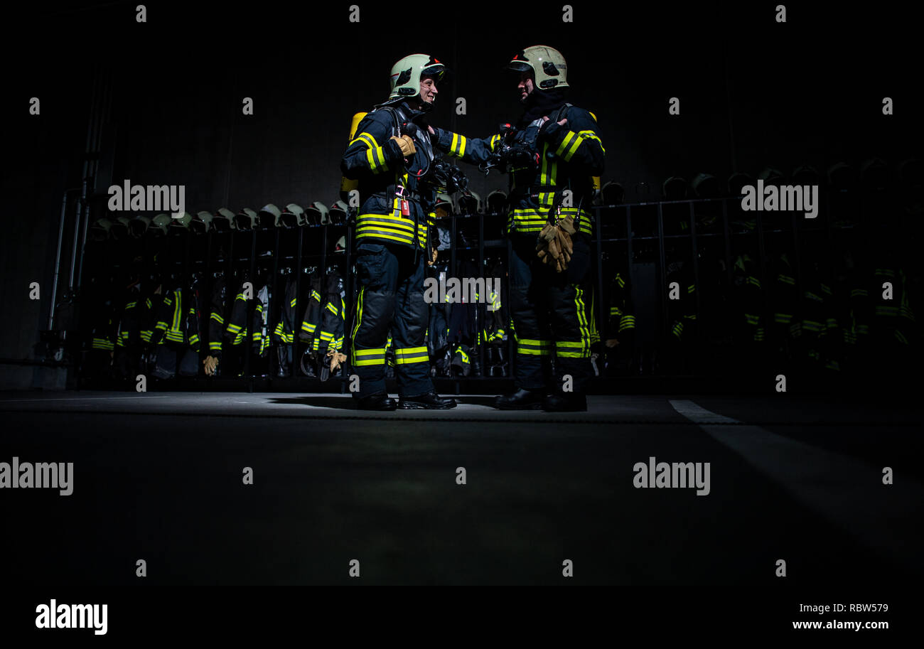 10 January 2019, North Rhine-Westphalia, Gelsenkirchen: The firemen Thomas (r) and Sven are standing in front of a wall with equipment of the fire station in Gelsenkirchen. After the great success of the first season, which ran on WDR television in mid-2017 and was nominated for the German Television Prize, the documentary series will be continued on WDR television from 21 January to 25 March 2019, Monday from 8.15 p.m. The production effort was enormous: 70 days in a row, 24 hours a day the 20-man TV crew shot. During the missions, up to 57 special cameras ran simultaneously and recorded almo Stock Photo