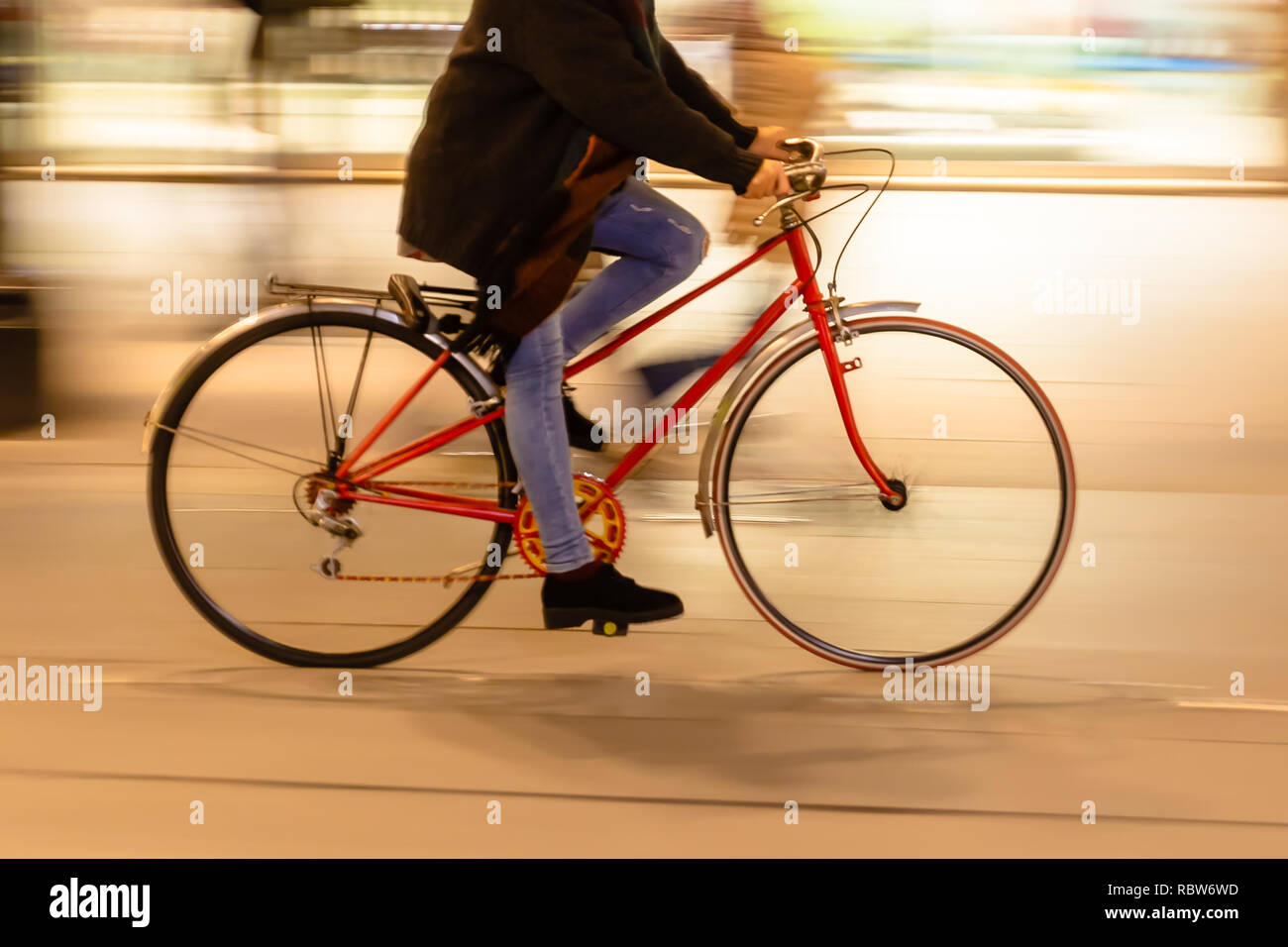 bicycle rider in the city at night, with camera made motion blur effect ...